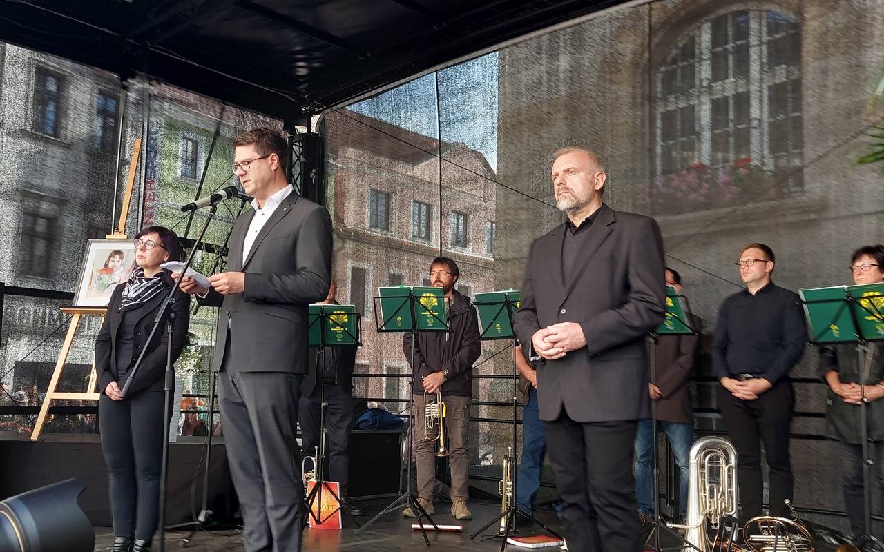 Unnas Bürgermeister Dirk Wigant steht gemeinsam mit Döbelns Oberbürgermeister Sven Liebhauser und dessen Stellvertreterin Susan Zache (von rechts nach links) auf der Bühne bei der Gedenkfeier für die neunjährige Valeriia am 14. Juni 2024 in Döbeln.