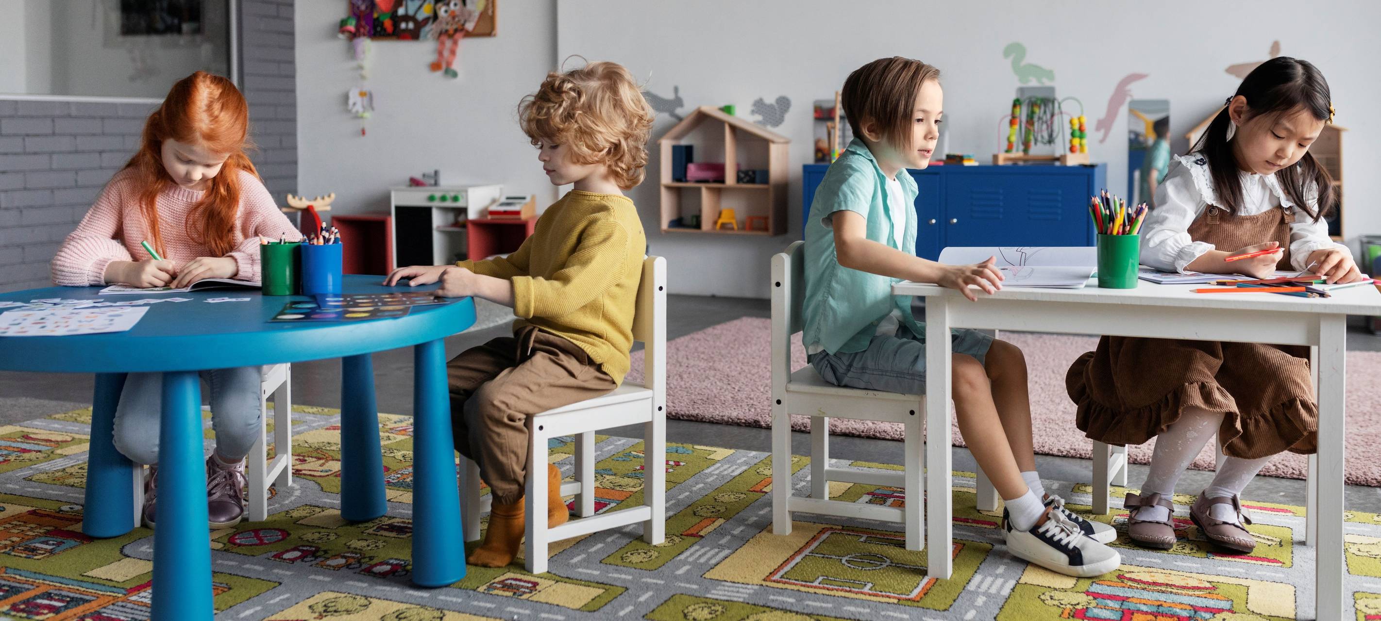 Kinder malen an Tischen in der Kita