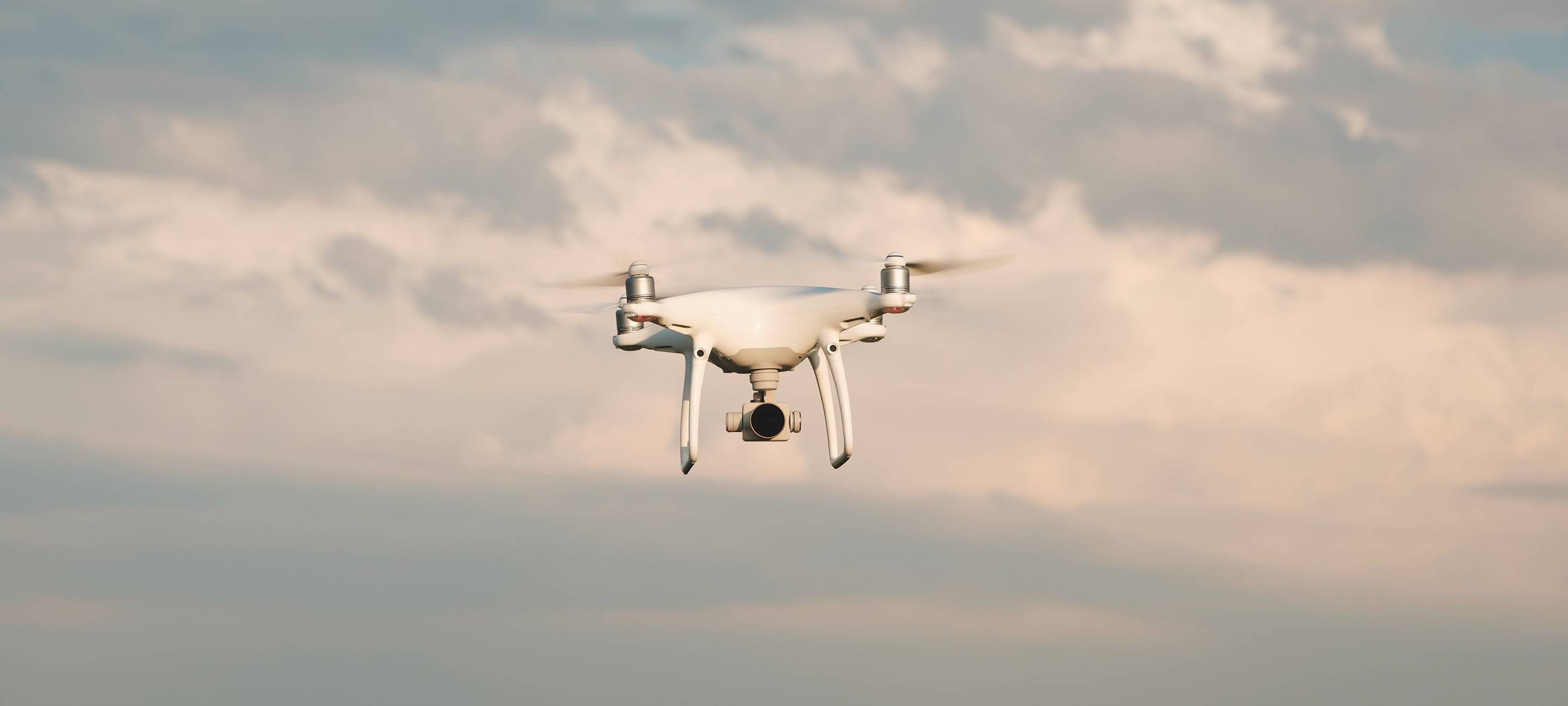 Fliegende weiße Drohne am Himmel