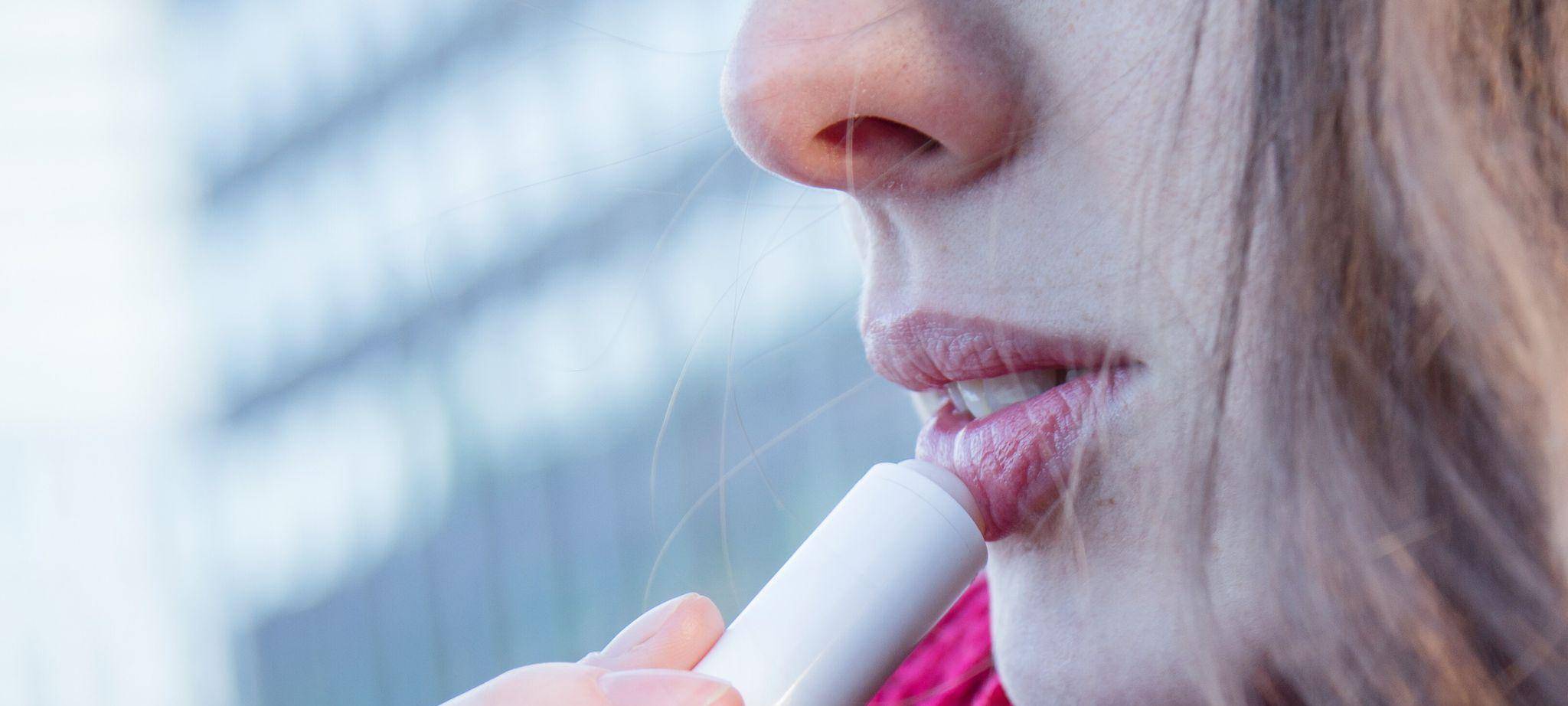 Frau trägt eine Lippenpflege auf